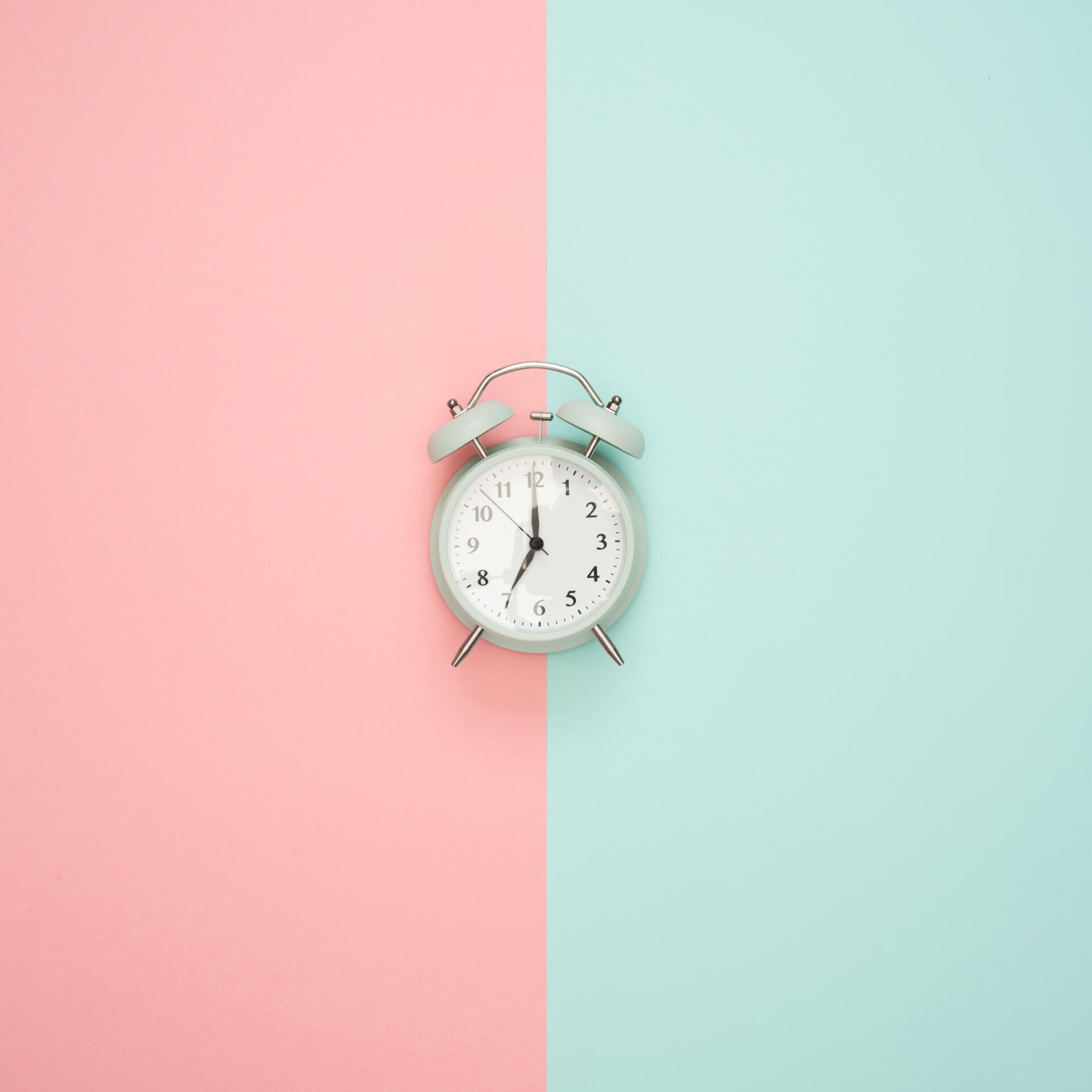 Blue clock on a pastel background.